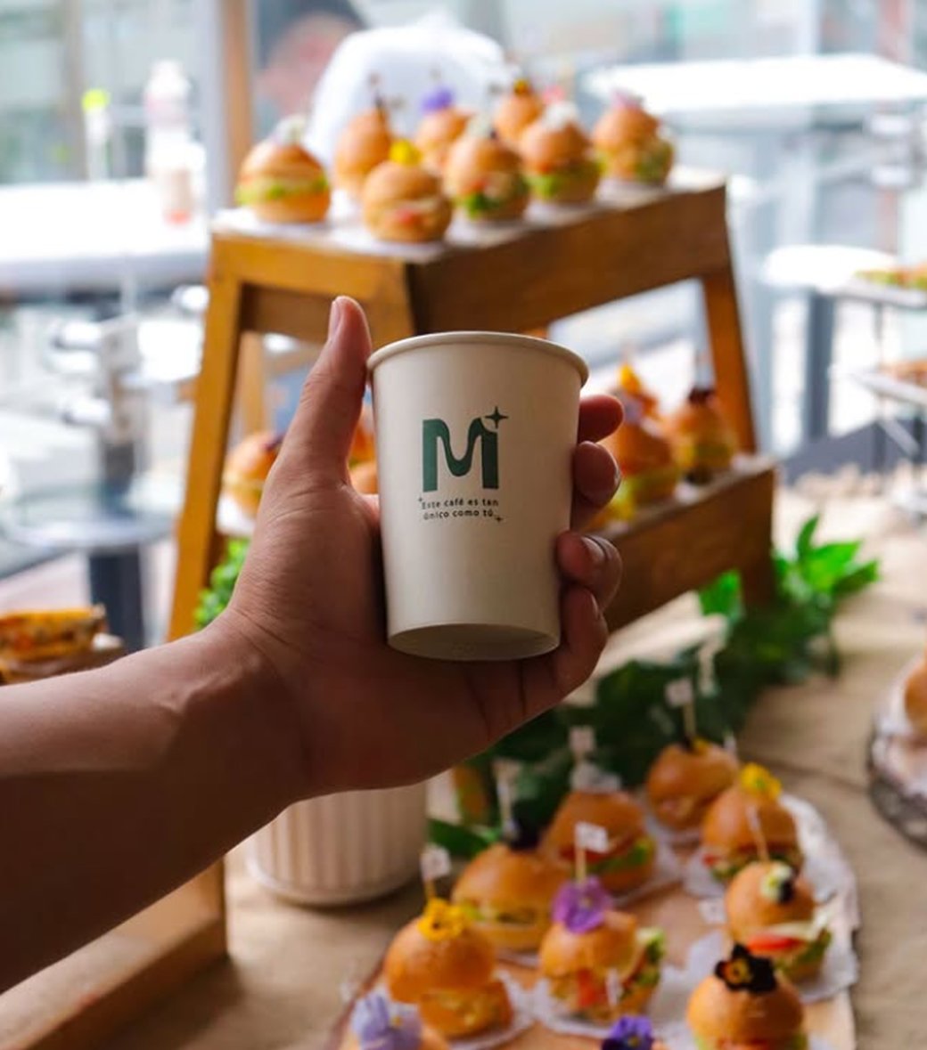 Barista Maseer sosteniendo un vaso con la marca